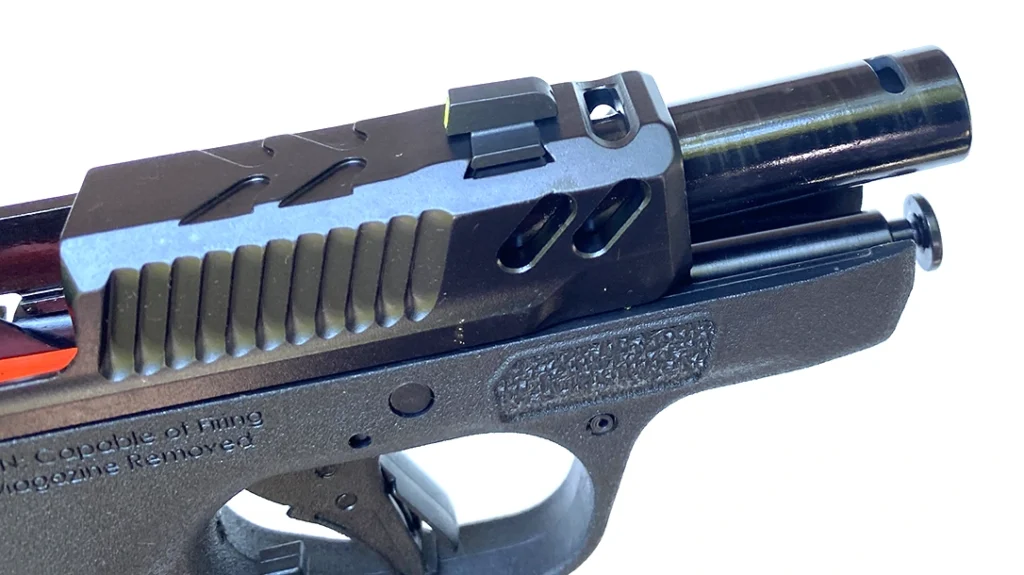 It has a single gas port cut along the top just behind the muzzle that matches up with a similar oblong hole cut through the top of the proportionally lengthened slide.