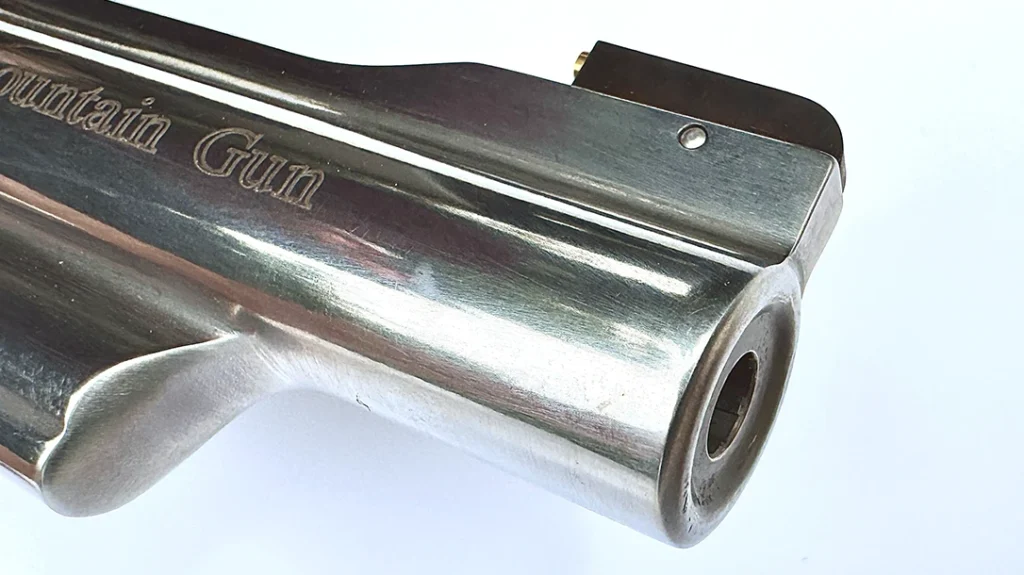 Its tapered barrel is 4.125 inches in length, and has an integral serrated rib on top, and an ejector rod shroud below.