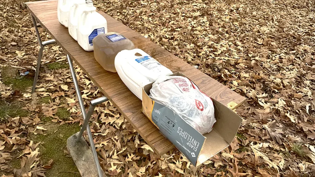 The flesh target was backed up with water jugs to catch the bullets undamaged for study.